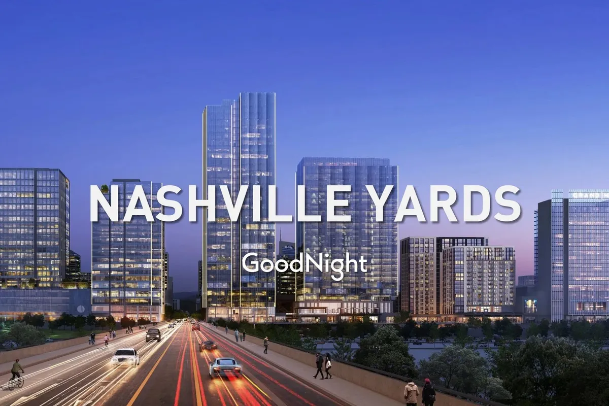An energetic city scene featuring illuminated skyscrapers, bustling streets, and pedestrians, evoking the vibrant urban atmosphere of downtown Nashville. The image captures the pulse of a thriving business district after hours, with nearby restaurants and shops visible along busy sidewalks.